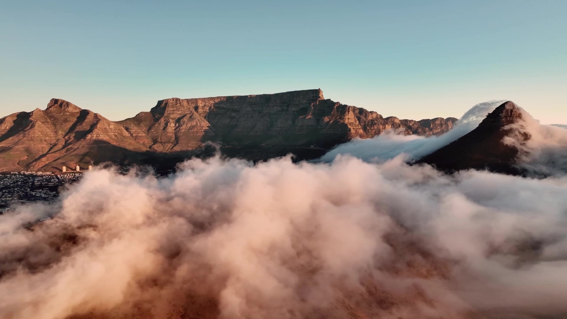 Table Mountain and Lion's Head at golden hour, rising above a sea of cloud